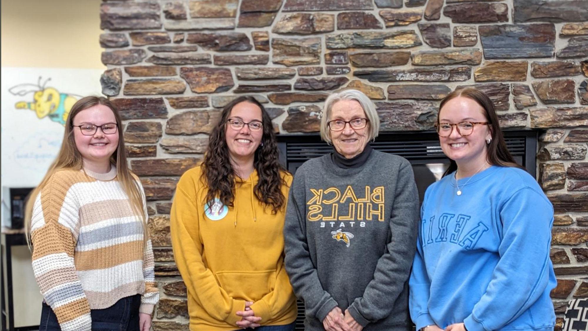 Black Hills State University students meet with the donor of their scholarships, Carol Lundberg. Lundberg recently increased her scholarship, adding three new recipients this spring. Standing (left to right) are Hadley Marquardt, Carol Lundberg, Marissa Tuttle, and Katie Pedneau.